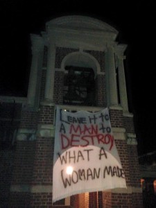 "Leave it to a man to destroy what a woman made" - banner hanging on the bell tower.