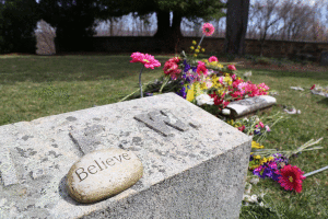 A stone laying atop Indiana Fletcher Williams grave, "Believe" sits next to Daisy's resting place.